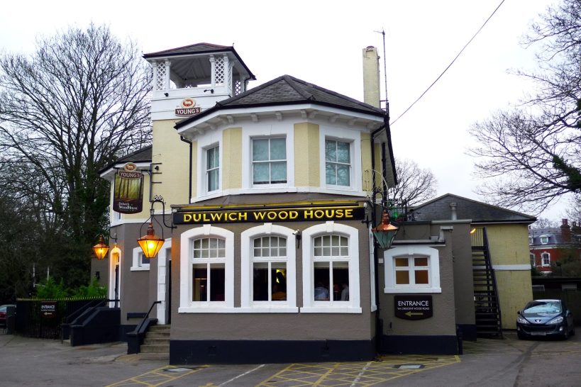 A quaint pub with a distinctive facade and outdoor seating area.
