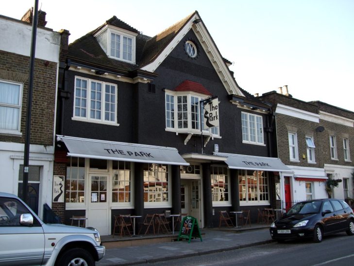 Black and white building with a pub signage and outdoor seating area.